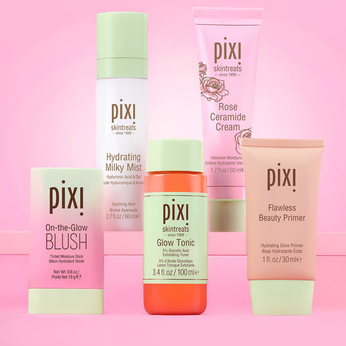 Six Pixi skincare and cosmetic products arranged together on a pink background. The products include Pixi Flawless Beauty Primer, Pixi On-the-Glow Blush, Pixi Glow Tonic, Pixi Hydrating Milky Mist, Pixi Rose Ceramide Cream.  view 1